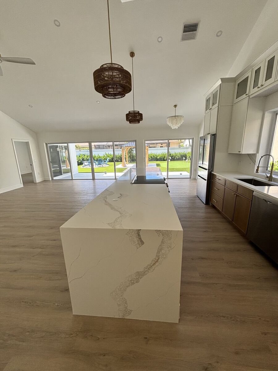 Waterfall quartz island with marble veining, pendant lights and new flooring