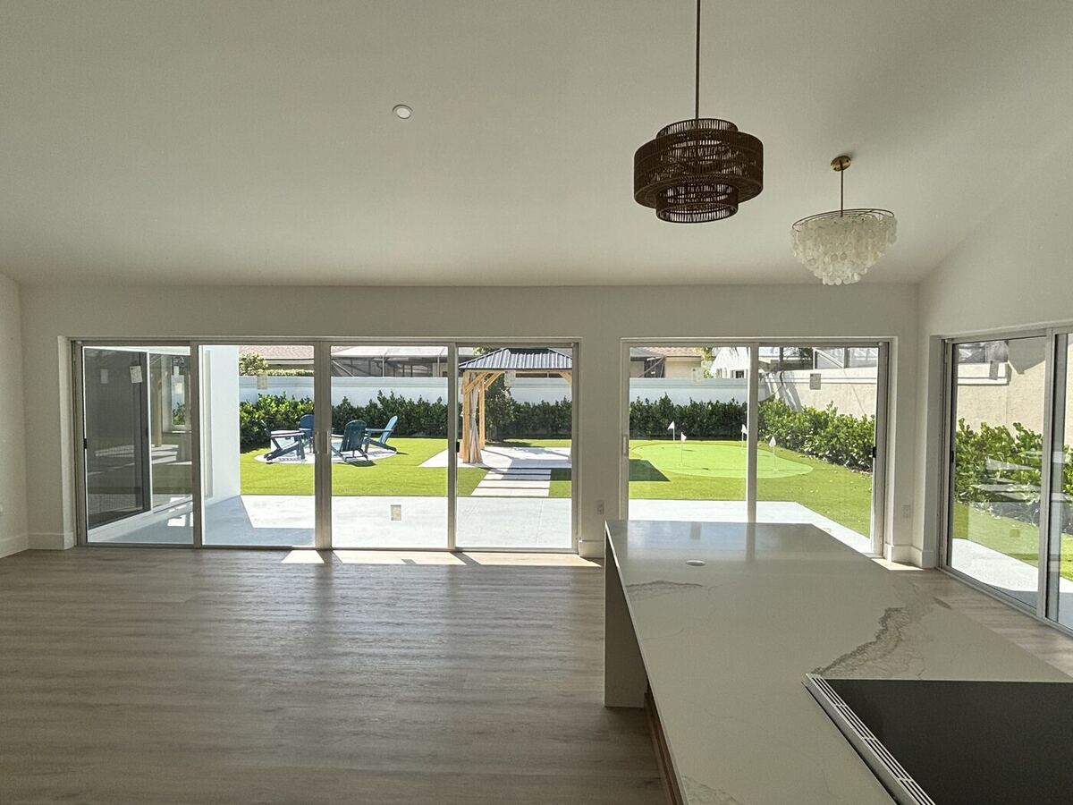Open living area with wood-look plank floors and sliding glass doors to the new backyard